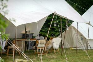 une tente dans le champ avec une lanterne et une en bois clôture. photo