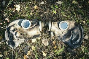 un vieux utilisé gaz masque mensonge sur le humide herbe sur le sol photo