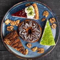 beau beignet, gâteau au chocolat et tiramisu sur la plaque bleue, vue de dessus photo