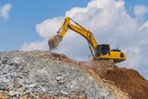 Excavatrice travaillant à l'extérieur sous le ciel bleu photo