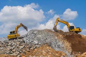 Excavatrice travaillant à l'extérieur sous le ciel bleu photo