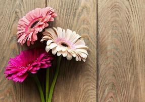 Fleurs de gerbera lumineuses sur un vieux fond en bois photo