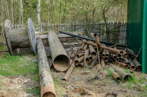 le tuyaux sont empilés pour décharge, une pile de des ordures de le fer tuyaux photo