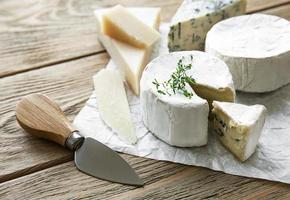 Différents types de fromage, fromage bleu, bree et camembert sur une table en bois