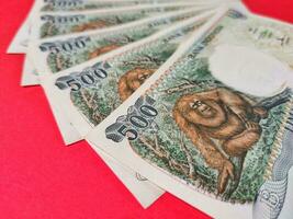proche en haut vue de vieux indonésien billets de banque 500,00 rp Publié dans 1992. Rupiah devise concept isolé sur une rouge Contexte. photo