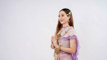 Thaïlande traditionnel culture, luxe portrait de une magnifique thaïlandais femme dans traditionnel thaïlandais costume posant à Payer le respect avec souriant isolé sur blanc Contexte photo