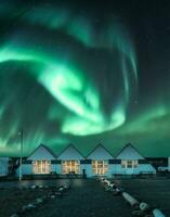 nord lumières ou aurore borealis embrasé plus de illuminé huttes dans l'automne à Islande photo