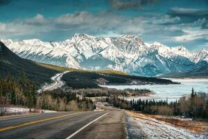 vue de Autoroute route dans le rocheux montagnes et congelé Lac dans champs de glace promenade photo