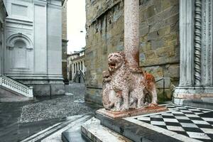 près le entrée à le Basilique de Père Noël maria maggiore dans Bergame porte de rouge les Lions photo