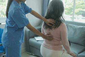 jeune physiothérapeute asiatique travaillant avec une femme âgée sur la marche avec un déambulateur photo