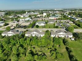 une étourdissant aérien vue de une Résidentiel quartier, révélateur bâtiments et des arbres ensemble contre roulant vert paysages. photo