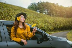 les femmes asiatiques sont en vacances. conduisez avec plaisir en vous rendant au jardin de fleurs de tournesol mexicain en thaïlande. photo