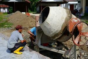 kuaro kalimantan Timour, Indonésie 01 mai 2023. ouvriers sont en utilisant une béton mixer pour cimentation photo