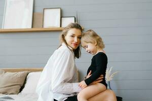 maman et sa fille câlins ensemble tandis que séance sur lit photo