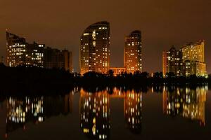ville de nuit avec reflet de maisons dans la rivière photo