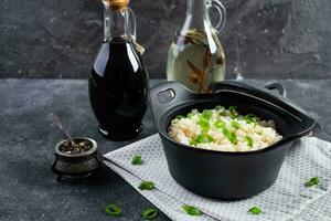 cuit riz avec poulet dans une pot sur foncé gris Contexte photo