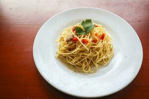 Aglio e olio. italien Pâtes spaghetti, Aglio olio e pepperoni ,spaghetti avec ails, olive pétrole et Chili poivrons sur assiette sur table photo