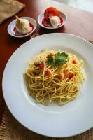 Aglio e olio. italien Pâtes spaghetti, Aglio olio e pepperoni ,spaghetti avec ails, olive pétrole et Chili poivrons sur assiette sur table photo