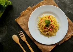 Aglio e olio. italien Pâtes spaghetti, Aglio olio e pepperoni ,spaghetti avec ails, olive pétrole et Chili poivrons sur assiette sur table photo