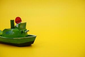bateau otok otok, une traditionnel jouet de Indonésie. une pop pop bateau jouet cette les usages vapeur pouvoir. jouet navire isolé Jaune Contexte. photo