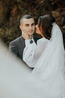 la mariée et jeune marié ayant une romantique moment sur leur mariage journée. magnifique voile, romantique la mariée. élégant jeune marié. photo