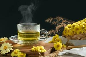 chrysanthème thé avec chaud vapeur et chrysanthème fleur dans panier sur noir Contexte. photo