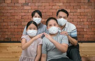 asiatique famille est portant masques faciaux pendant coronavirus et grippe épidémie. photo