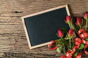 Vide tableau noir avec rouge des roses et cœur ruban photo