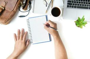 affaires homme écrire sur Vide carnet. blanc Bureau bureau table photo