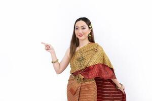 thaïlandais femme dans élégant riches traditionnel robe Faire main montrer du doigt et en présentant geste pour promouvoir culture dans Thaïlande isolé sur blanc Contexte photo
