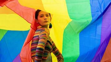 élégance transgenre modèle femme en costume de drapeau arc-en-ciel coloré danse dans le défilé homosexuel pour le mois de la fierté lgbtq et sort du placard concept pour l'égalité sexuelle et le concept de liberté photo