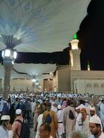 médina, saoudien Saoudite, mai 2023 - magnifique nuit temps vue de masjid Al nabawi, médina. visiteurs, cours à l'extérieur le mosquée, magnifique lumières et électronique parapluies pouvez aussi être vu. photo