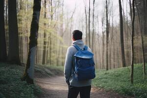 retour vue Jeune homme avec une sac à dos permanent le forêt. liberté et la nature concept. ai généré photo