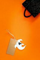 Halloween vente bannière avec étiqueter, fantôme et sac sur Orange Contexte. photo