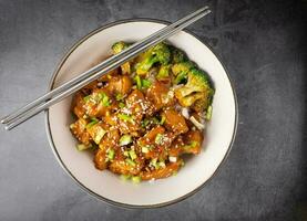 baguettes avec délicieux sucré couper poulet riz, sésame graines, tranché printemps oignons, brocoli, et des légumes. asiatique nourriture, Japonais aliments. Haut vue photo