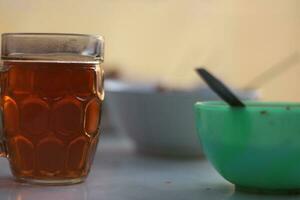 une verre de chaud thé sur une Contexte dans le Matin. photo