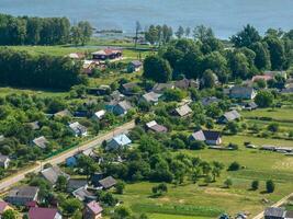 panoramique aérien vue de éco village avec en bois Maisons, gravier route, jardins et vergers photo