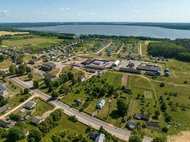 panoramique aérien vue de éco village avec en bois Maisons, gravier route, jardins et vergers photo