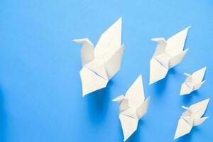 blanc oiseau origami papier sur bleu Contexte. oiseau paix, liberté ou Opportunités concept photo