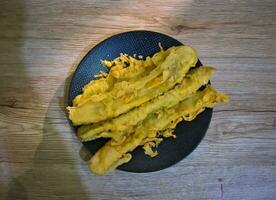 frit bananes sur une noir assiette sur une en bois Contexte photo