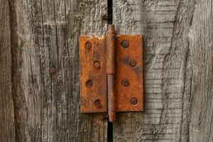 vieux rouillé charnière sur une en bois porte. vieux rustique Contexte photo