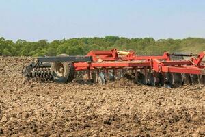 le tracteur charrues le sol avec une cultivateur briser mottes dans t photo