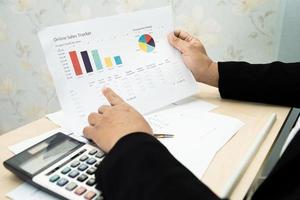 Comptable asiatique travaillant et analysant la comptabilité de projet de rapports financiers avec graphique graphique et calculatrice dans un bureau moderne