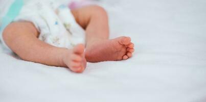 nouveau née bébé pieds sur blanc couverture. maternité et petite enfance concept. photo