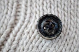 bouton noir sur la laine blanche photo