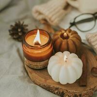 l'automne composition avec aromatique bougie dans verre pot avec en bois mèche, et bougie forme de citrouilles, citron thé dans tasse. concept de aromathérapie, méditation et bien-être photo