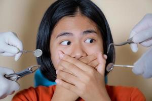 fille effrayée par les dentistes couvre sa bouche dans le bureau du dentiste