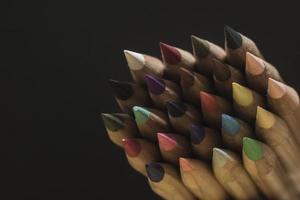 crayons de couleur pointus sur un espace de copie de fond noir photo