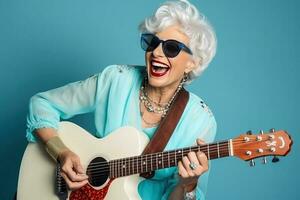 portrait de une cool branché vieux femme en jouant une guitare sur bleu studio Contexte. ai généré photo