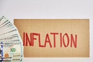 monde inflation concept. papier carton avec mot inflation et USD billets de banque photo